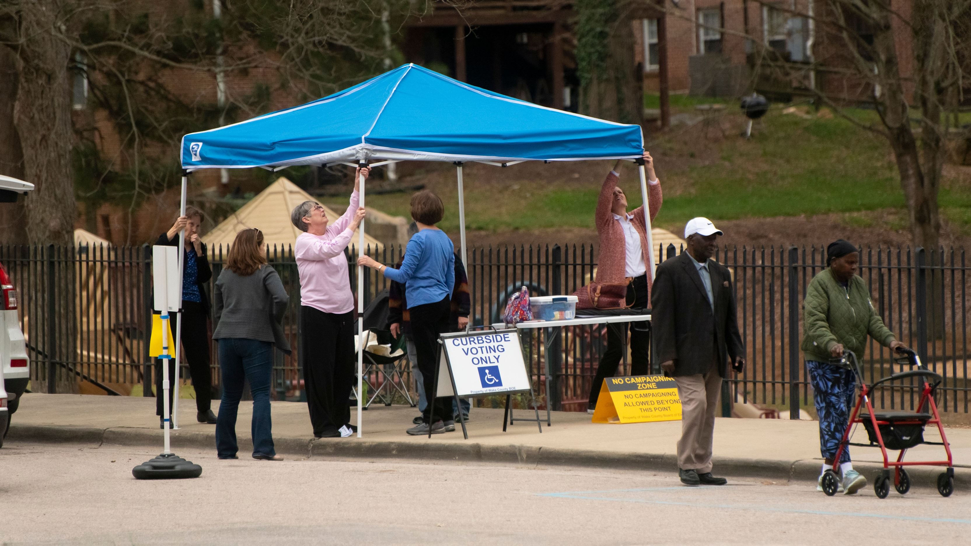 People assembling a curbside voting location