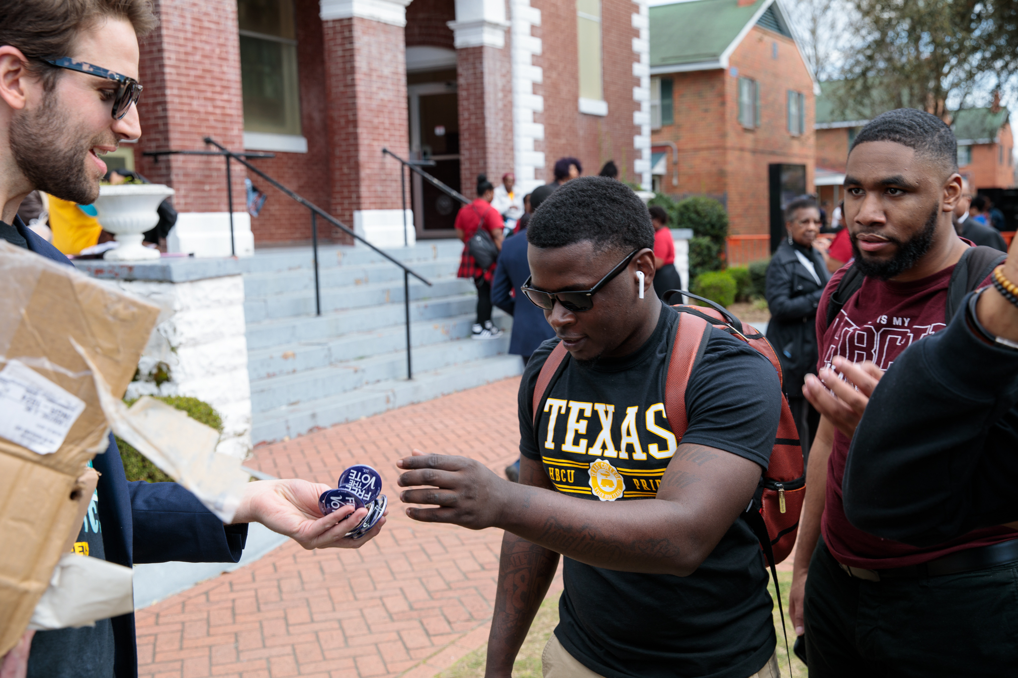 University students on a campus exchanging buttons that read "Free the Vote"