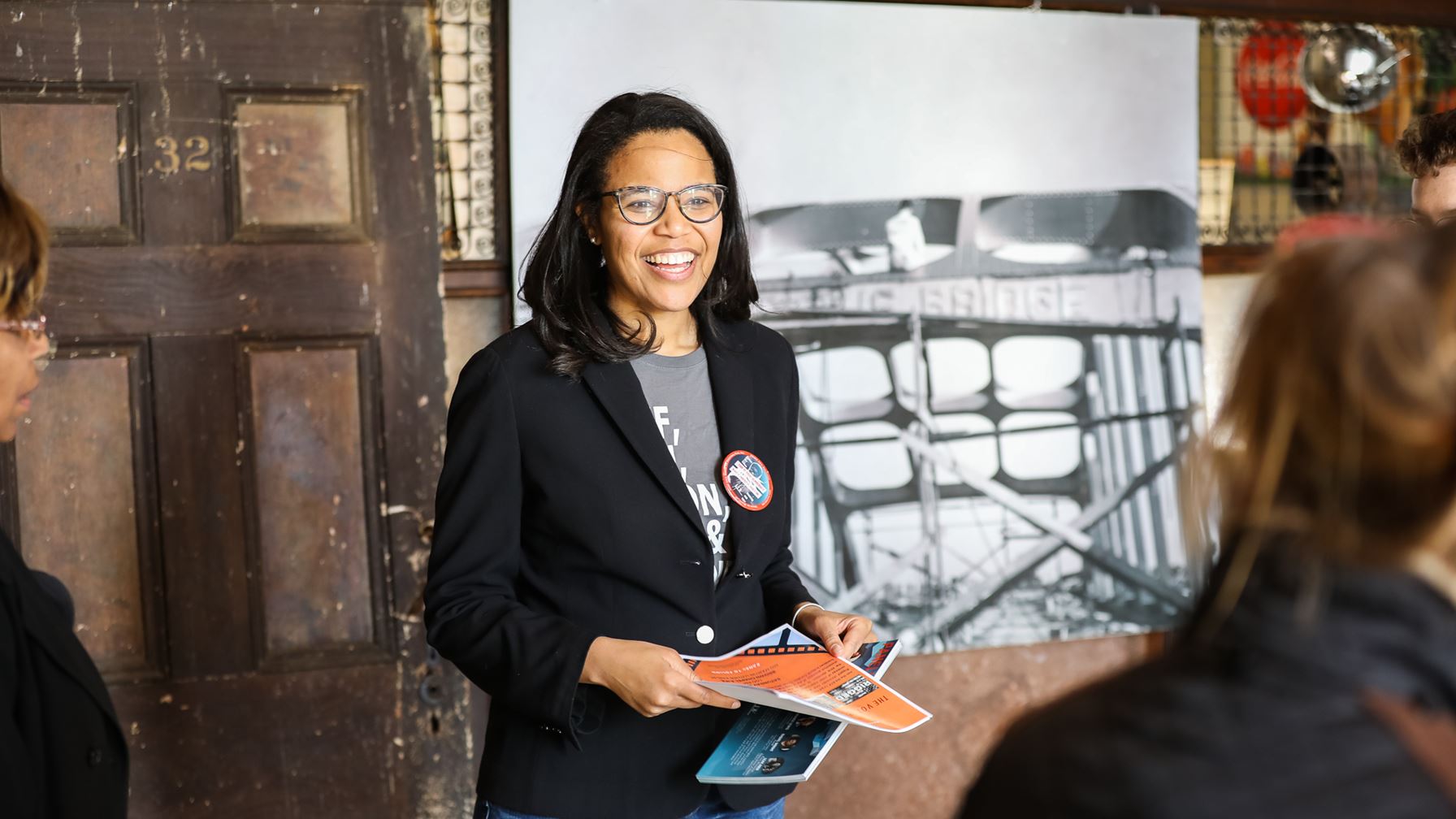 Woman smiling and handing out information sheets